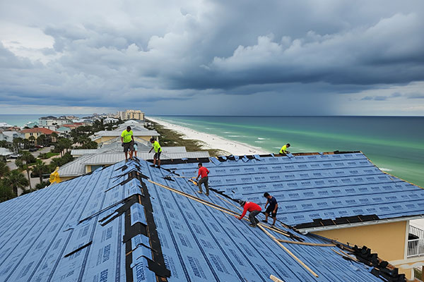 Roof repair being performed on a Perdido Key condo with wind-driven rain damage.